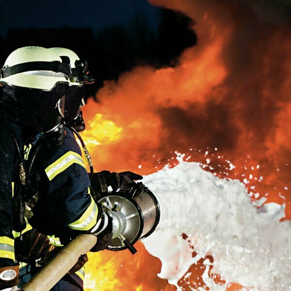 Firefighter with a hose throwing foam